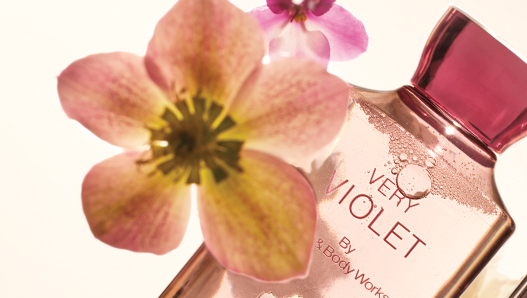 Violet flower beside a Very Violet perfume bottle