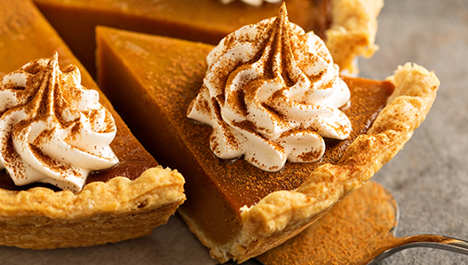 Individual pumpkin pies topped with whipped cream